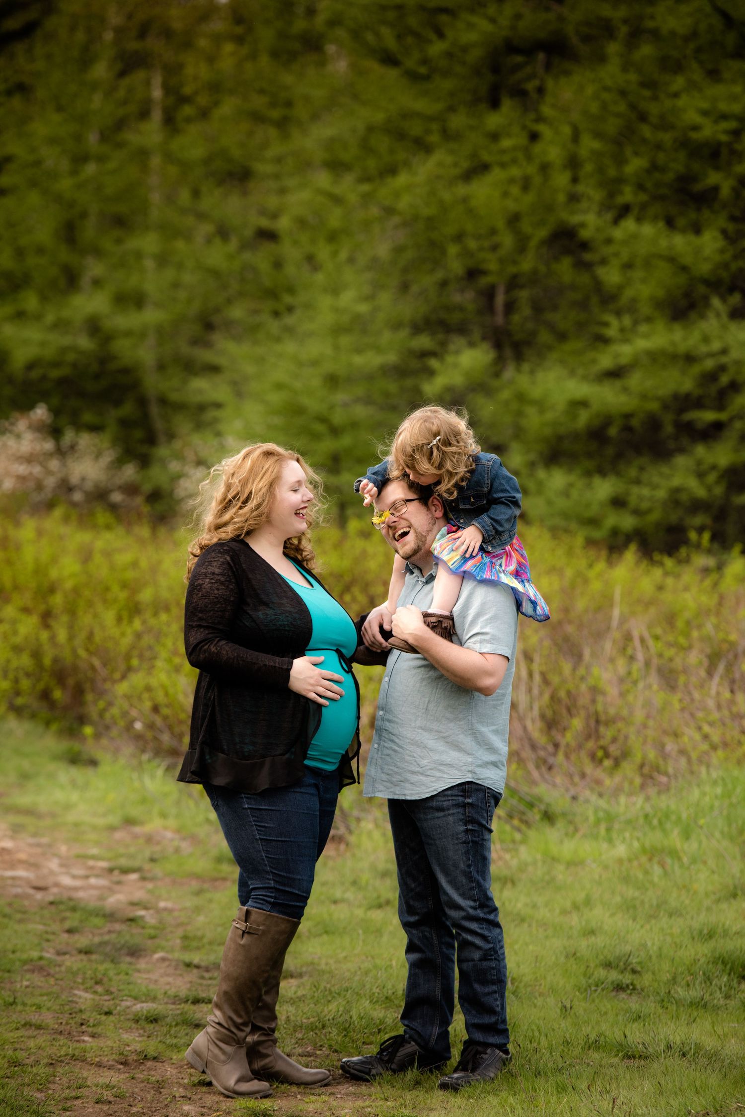 Couple sharing joyful moment on nature trail with evergreen forest background.