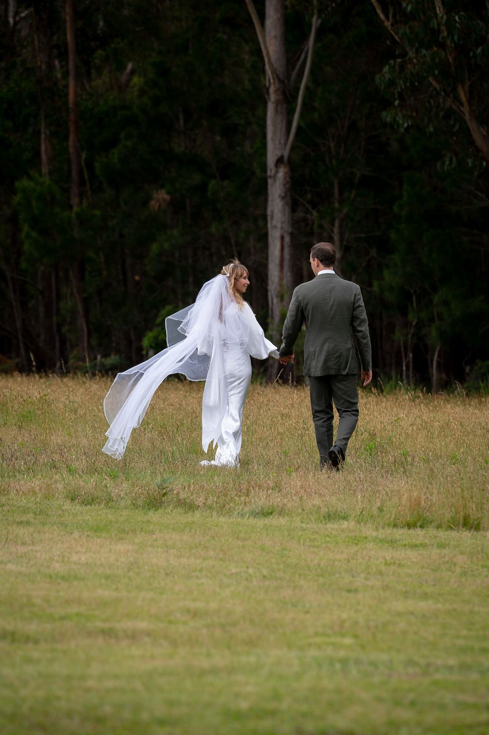 Bride and Groom walking towards the bush