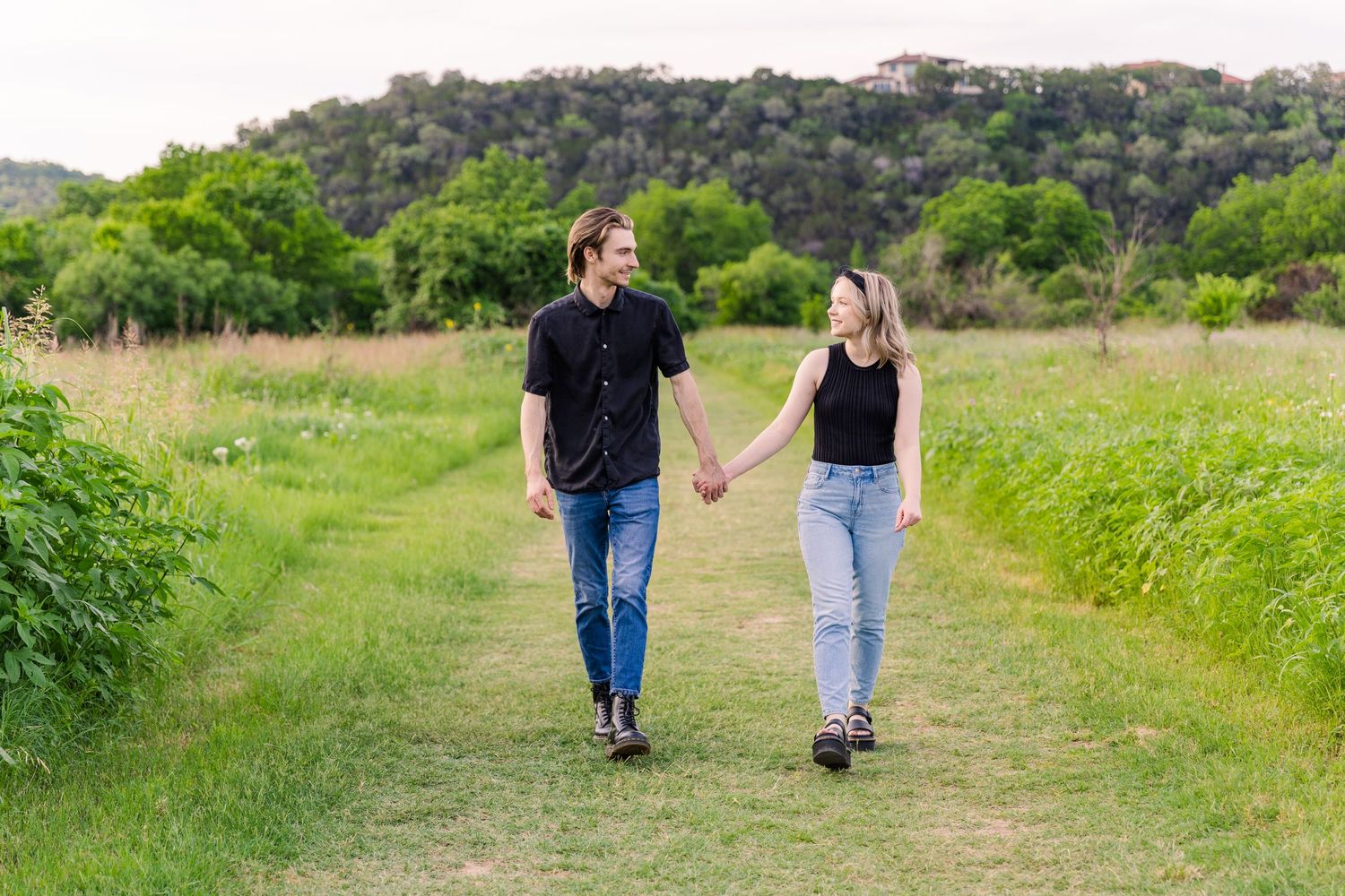 couple walking through path at Commons Ford Ranch