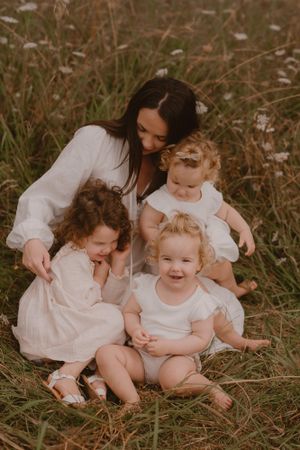 mum with her girls in hamilton field amongst the daisies
