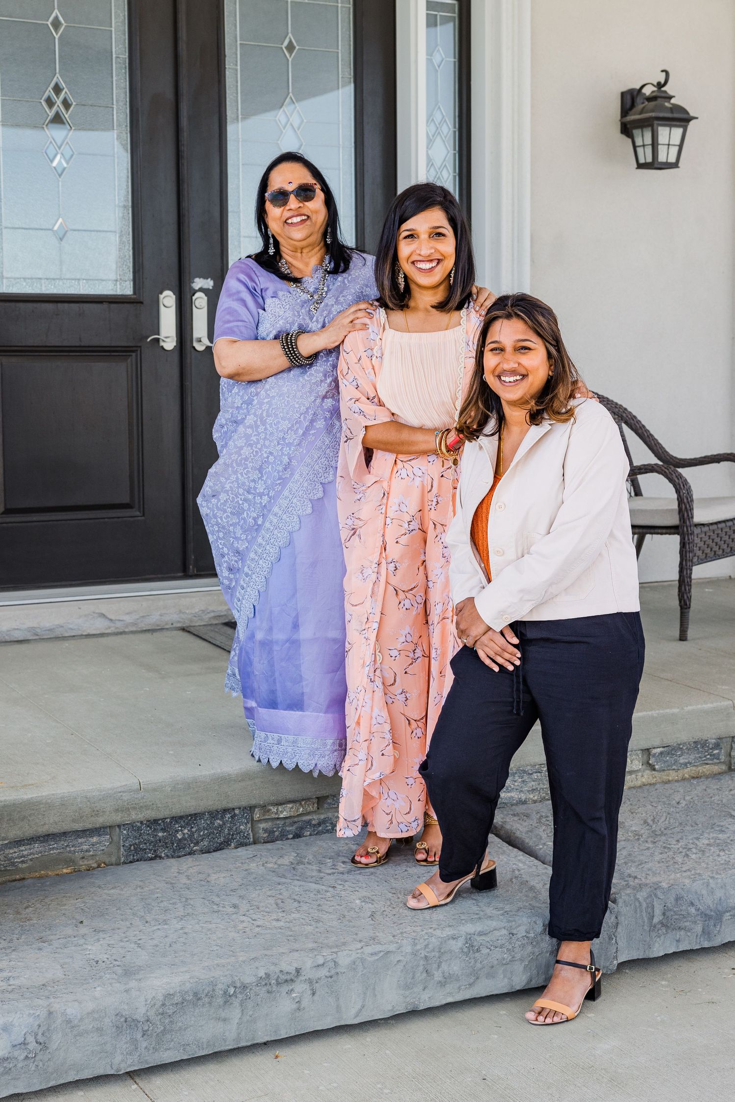Three people posed together on front steps of home wearing coordinated outfits.