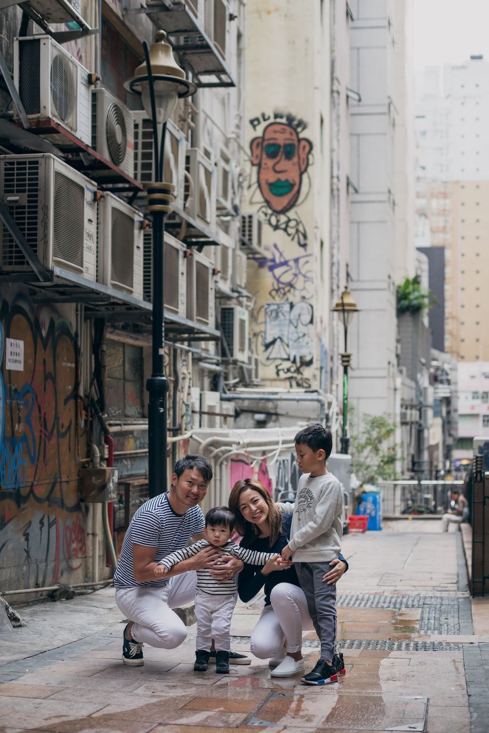 Happy family enjoying a playful moment together on a city street in Asia.