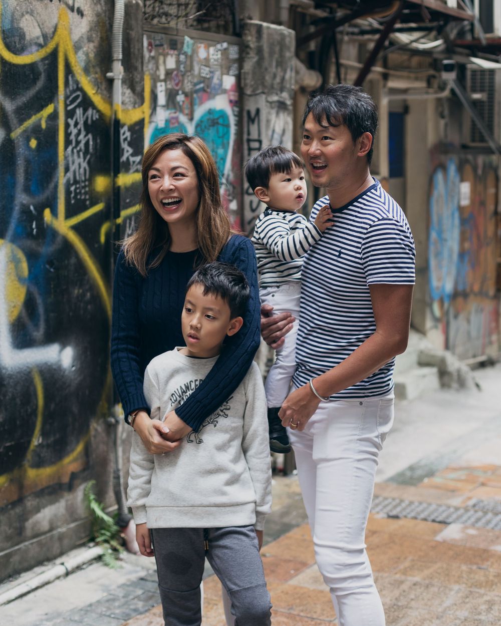 A candid family moment against urban street art and graffiti walls.