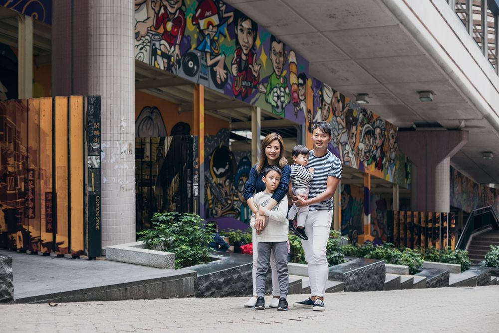 Modern urban family photoshoot in front of a contemporary building entrance.