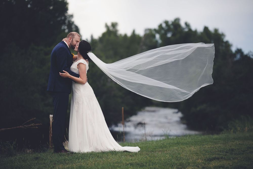 Floating veil shot of newly married couple in front of the Chama River at Log River Ranch