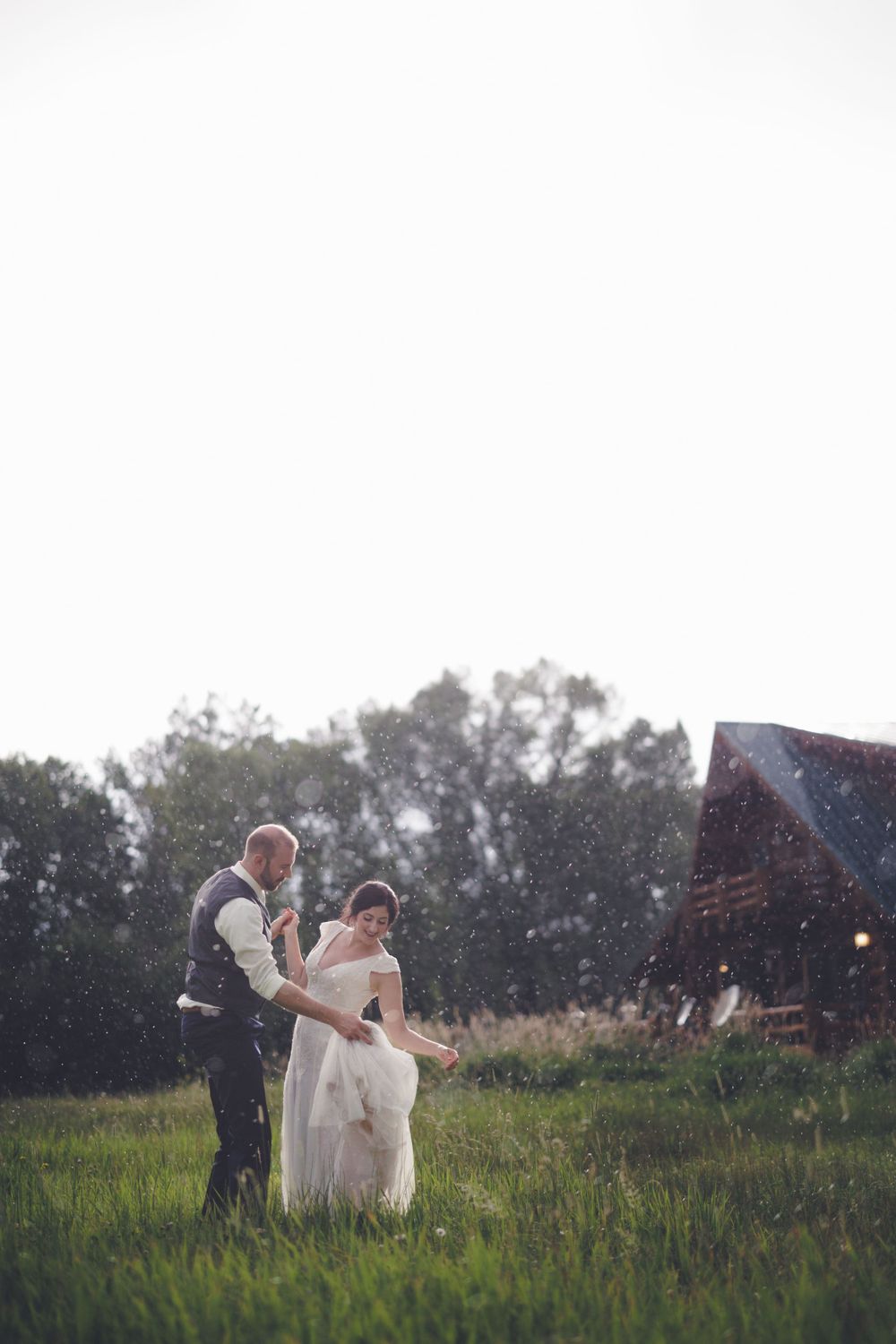 Wedding photo of couple dancing in the rain at Log River Ranch right before their reception