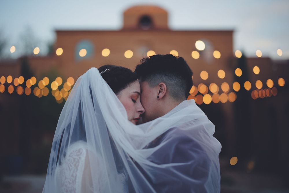 Two brides embrace one another at Blue Door Venue before their wedding reception