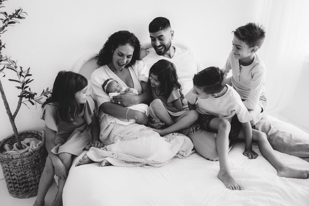 Black and white family photo during natural light newborn session in Phoenix AZ by Jen Roberts Photographer with focus on newborn smile