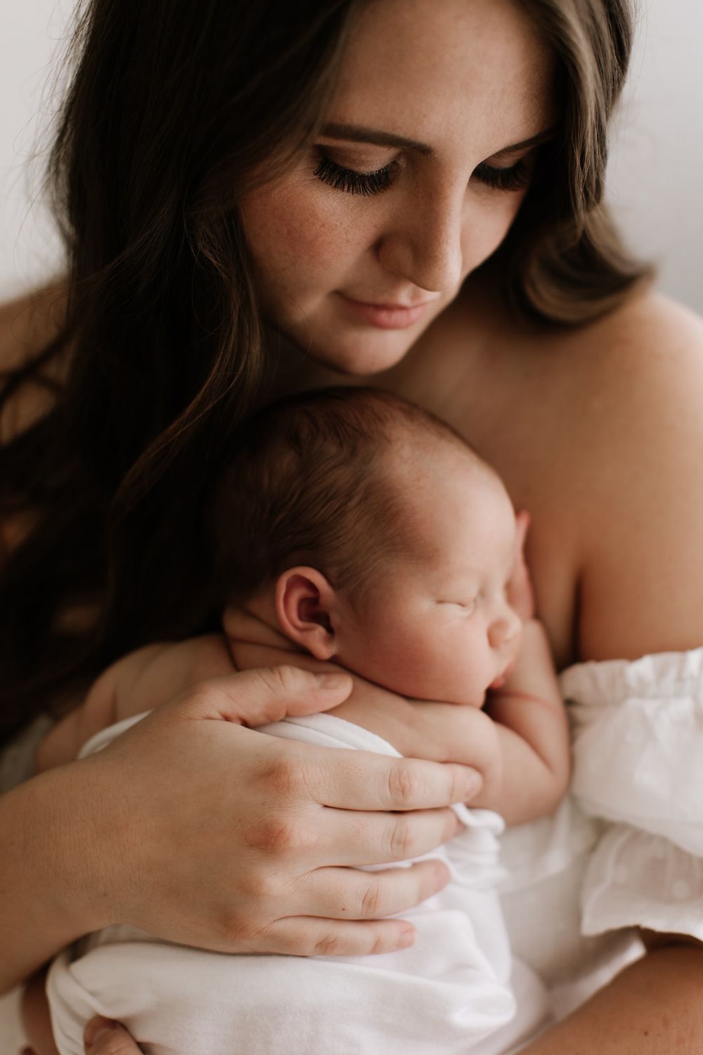 Mother and newborn cuddling during studio photo shoot in Phoenix, AZ by Jen Roberts