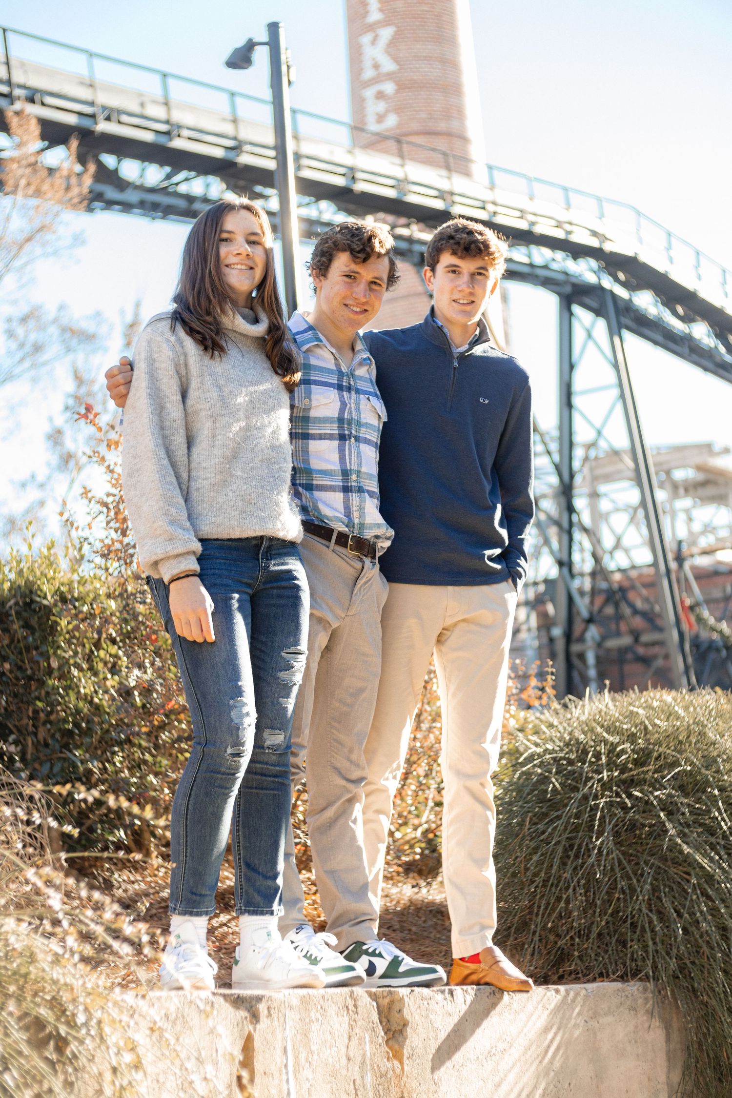 3 kids standing on wall