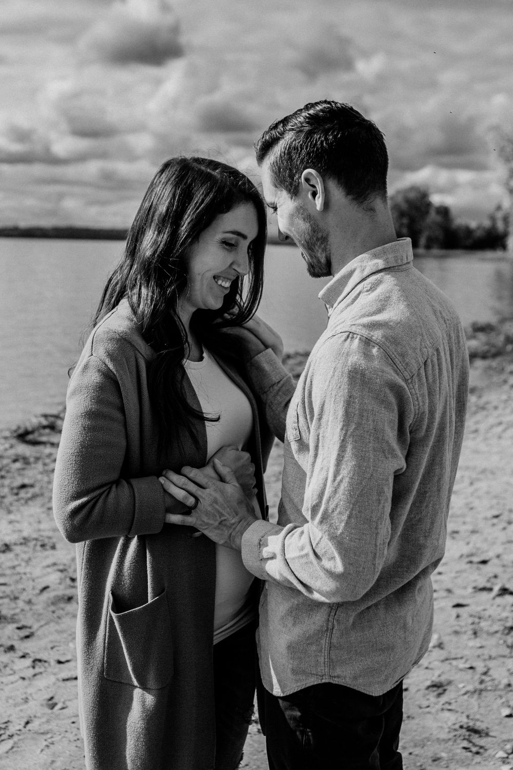 Black and white beach photos of a couple sharing intimate moments.