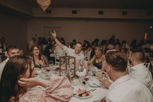 Wedding guests celebrate at decorated reception tables.