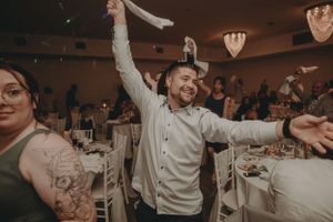 Enthusiastic dancing and celebrations during a wedding reception with heart-shaped ceiling decorations.