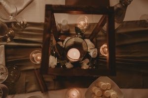 Vintage-style light bulbs and lanterns create warm ambient lighting in dark wooden frames.