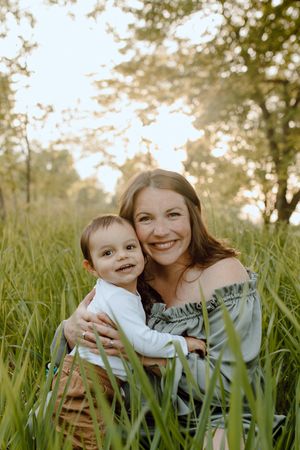 A tender outdoor portrait in tall grass during golden hour sunlight.