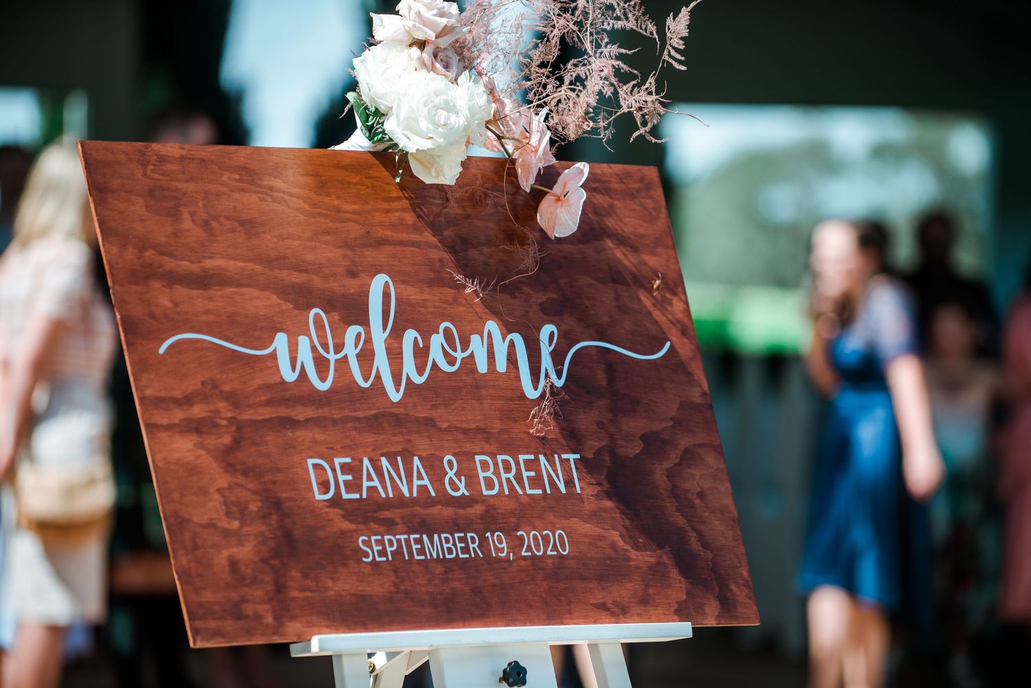 Wooden welcome sign with silver calligraphy for Deanna and Brent's wedding.