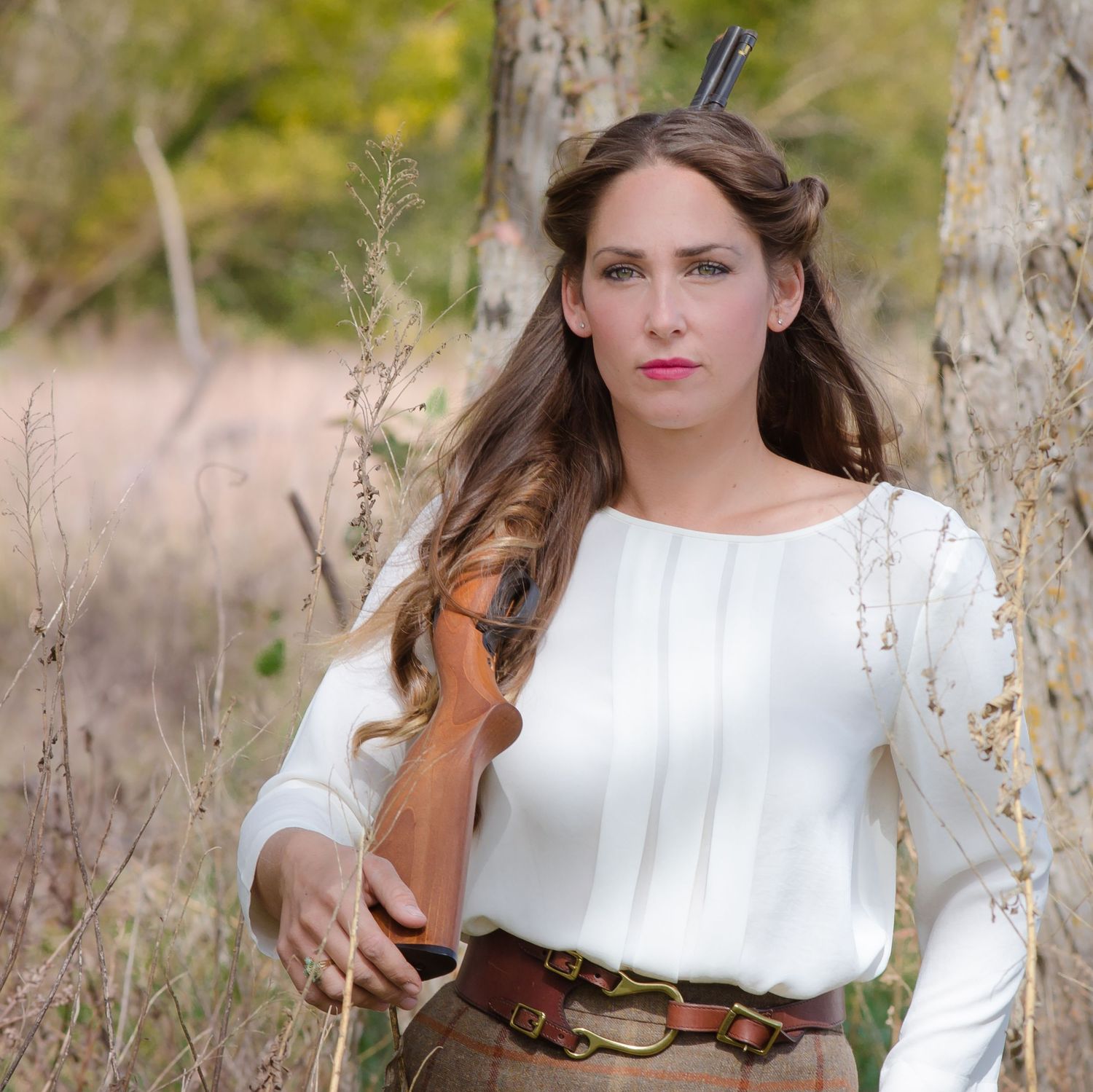 Woman outdoors with shotgun on shoulder