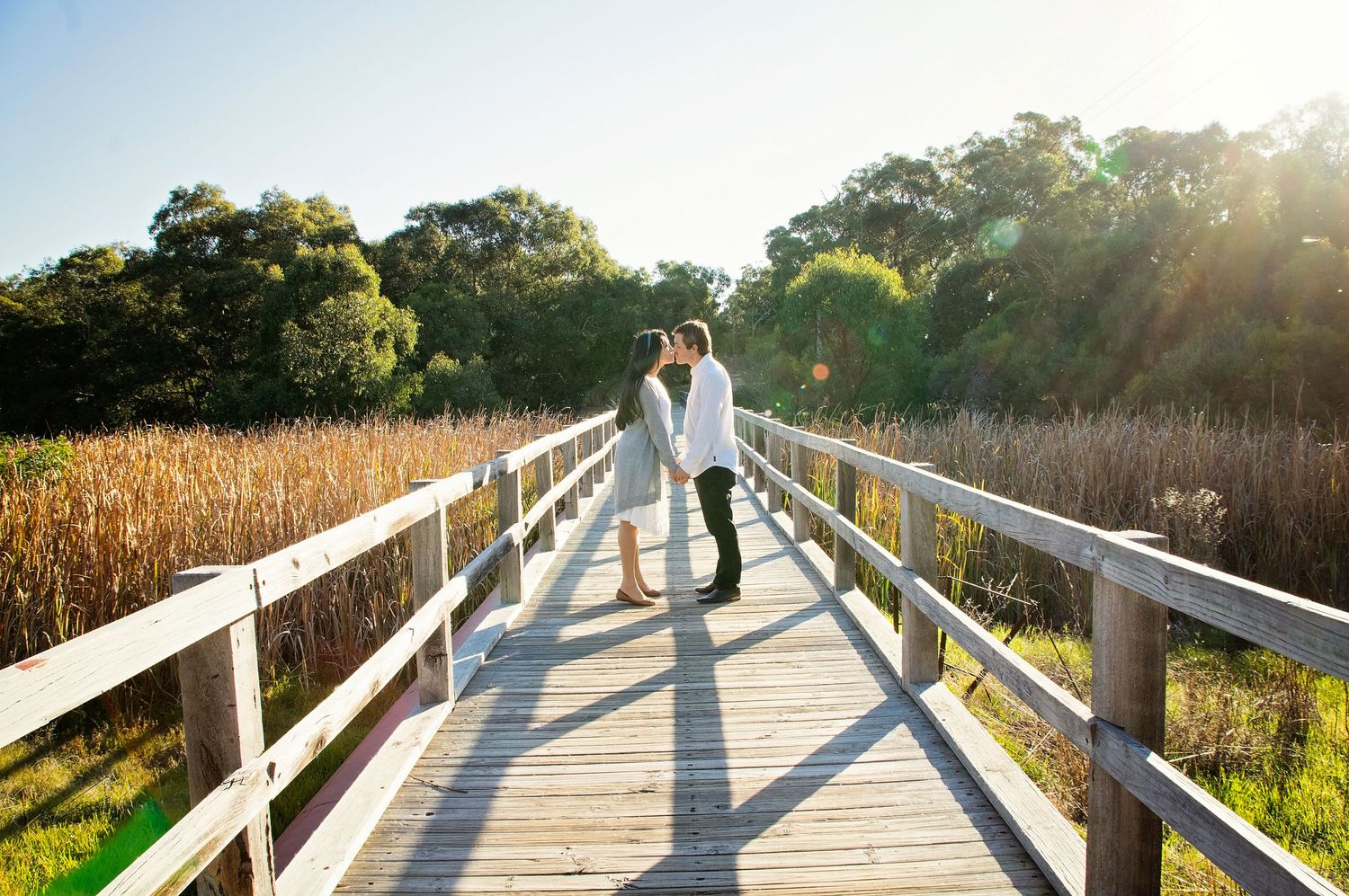 couple kissing on bridge