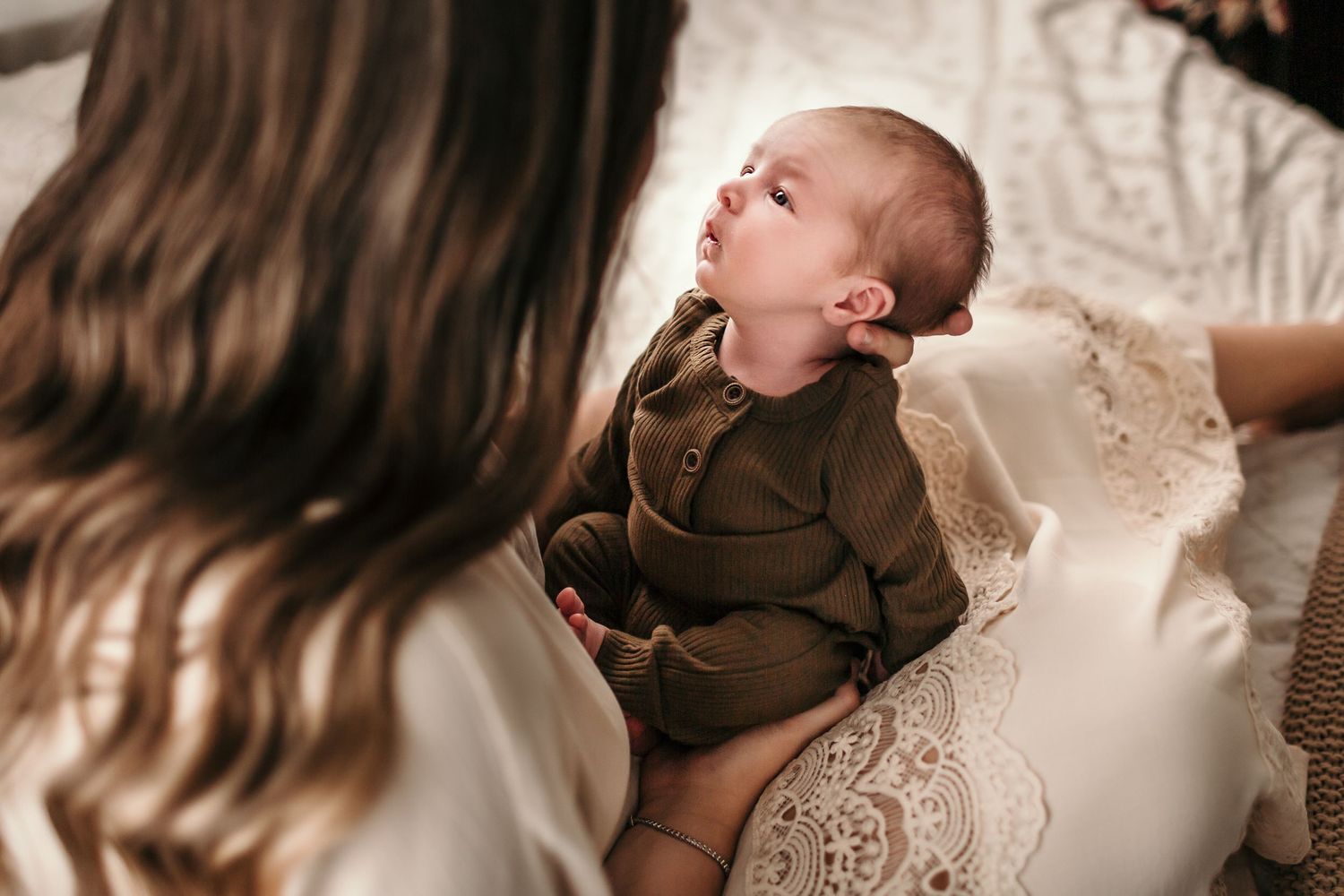 a mom is holding her baby and looking into his eyes