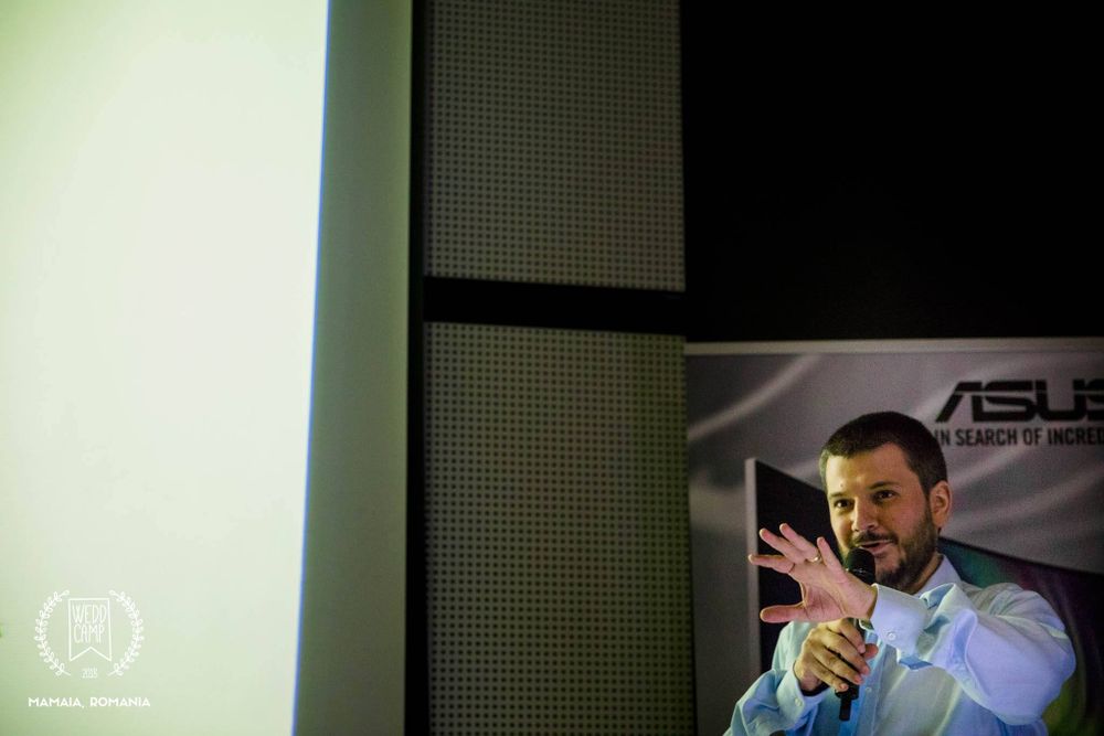 Speaker presenting at technology event with ASUS branding visible.
