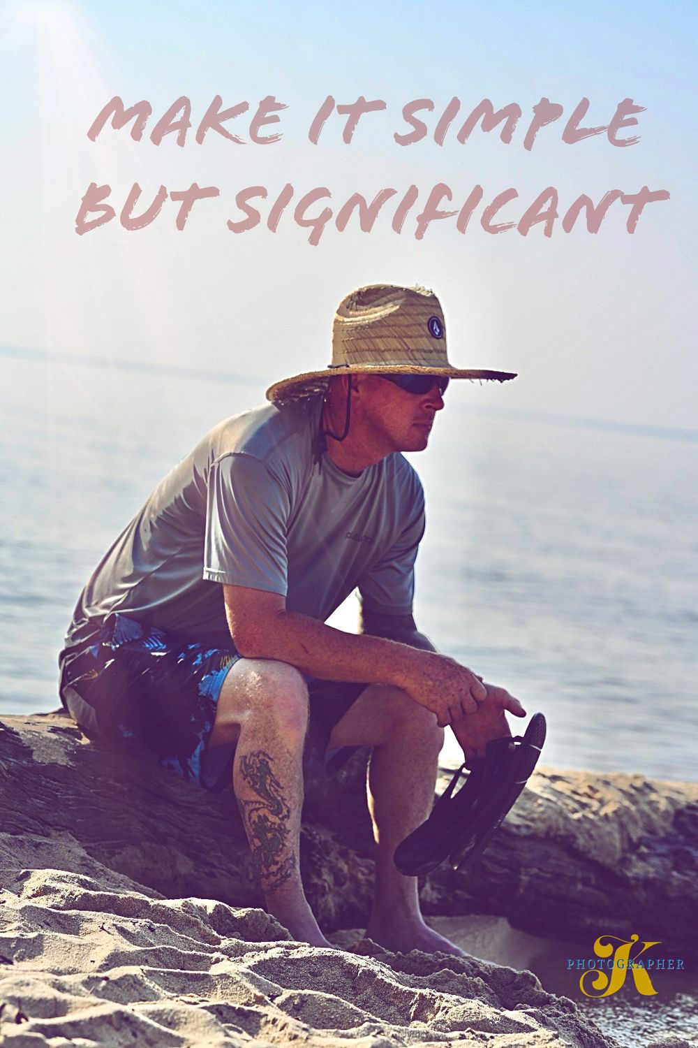 Person in hat sitting on coastal rocks with inspirational text overlay.