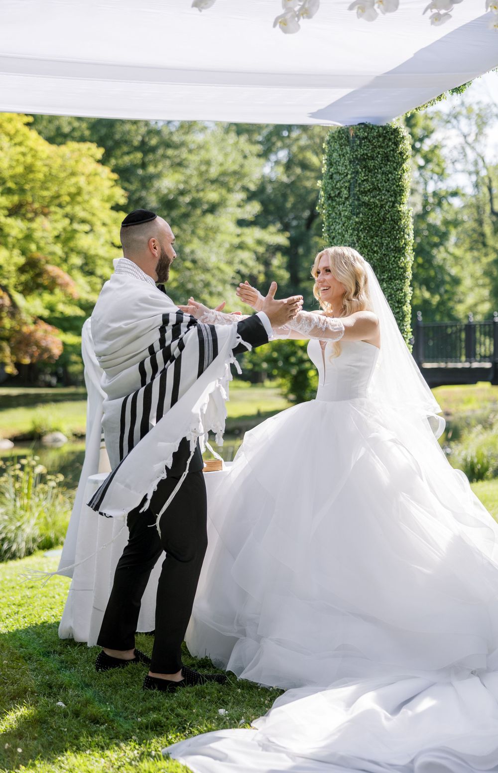 Joyful outdoor wedding celebration with bride in flowing white gown.