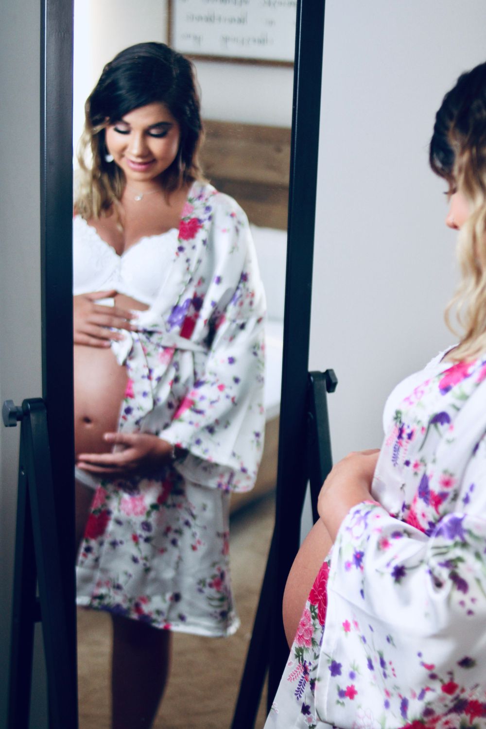 Intimate maternity session featuring floral robe in natural window light.
