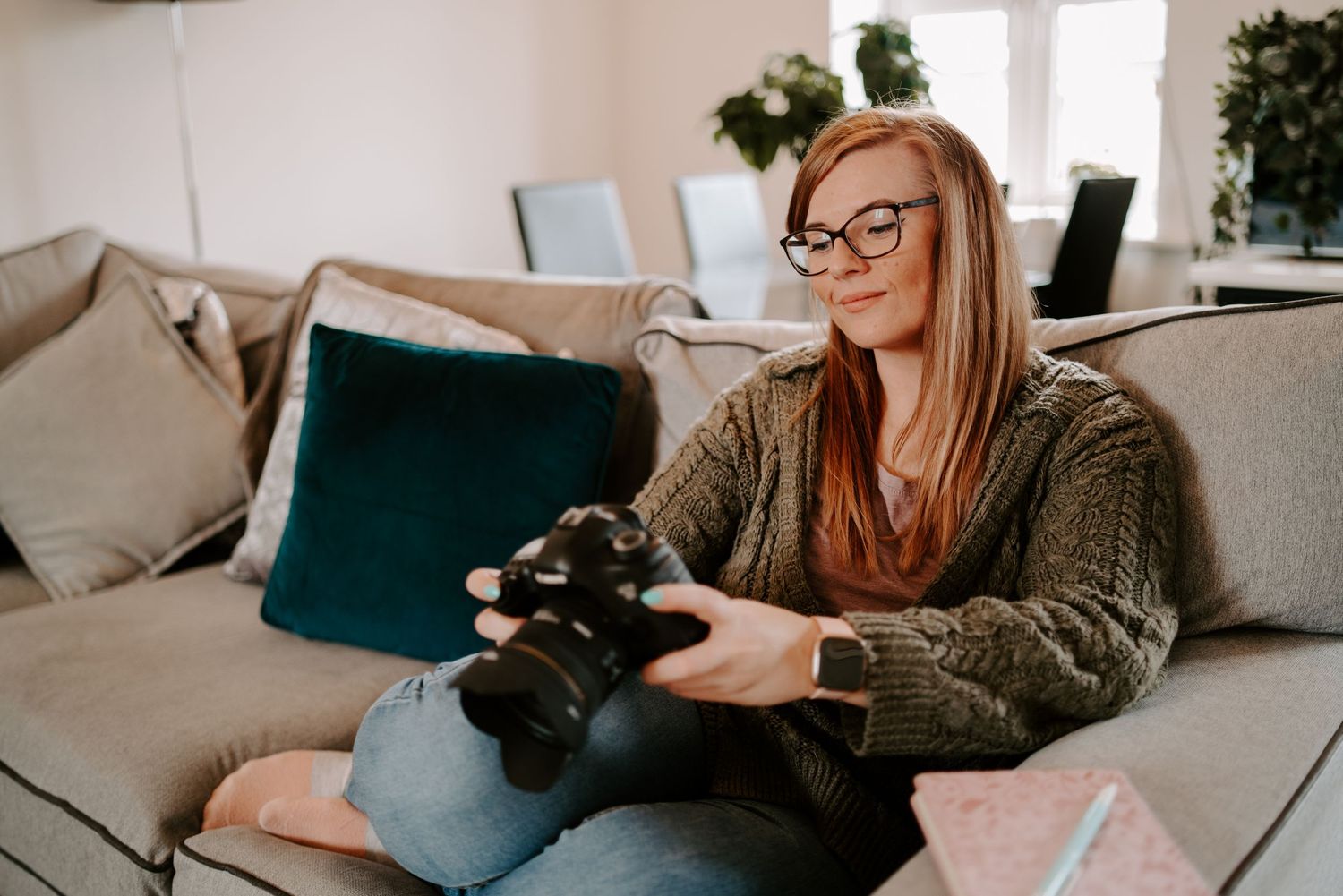 A relaxing scene of someone lounging on a couch with a black camera while enjoying a cup of coffee.