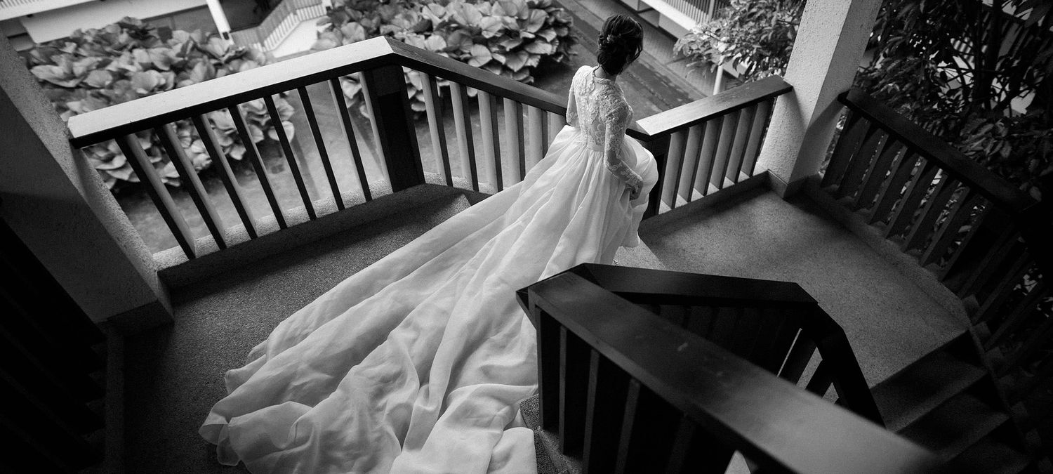 bride walking down the stair with her long white trails