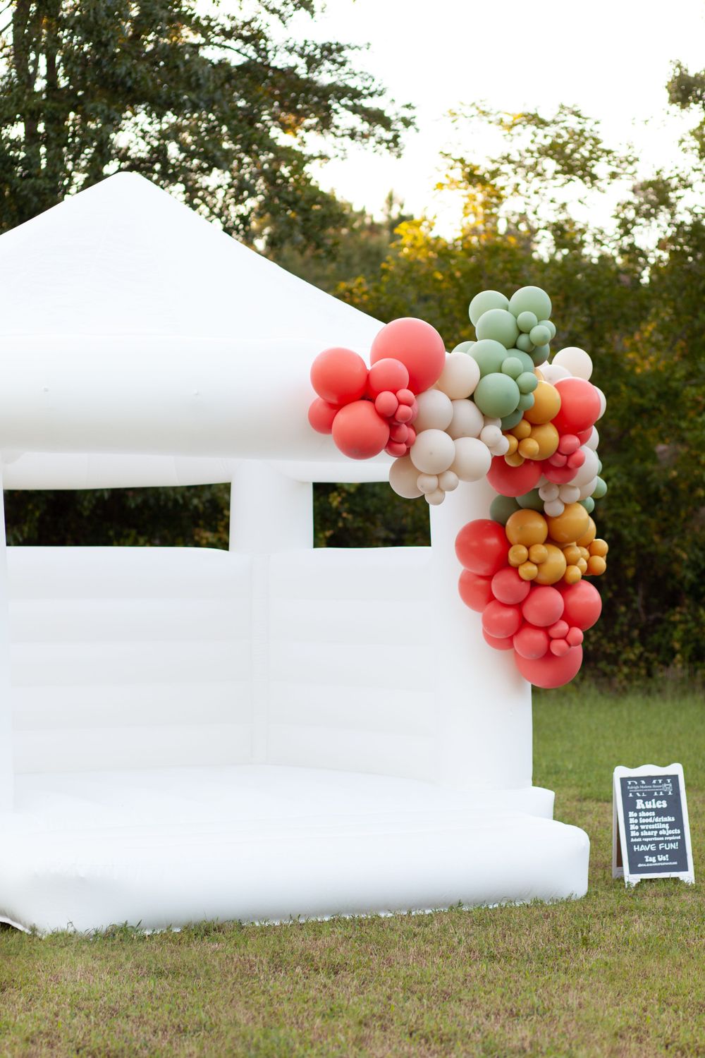A bounce house decorated with a muted balloon garland at the House on Barber Mill in Clayton, NC.