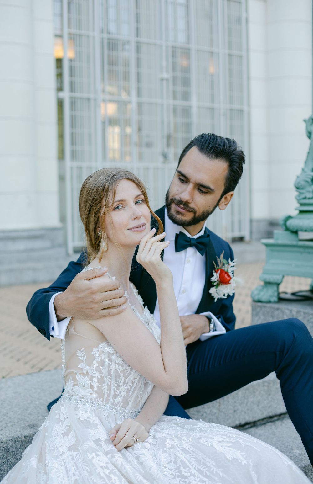A romantic wedding portrait on stone steps with the couple sharing an intimate moment.