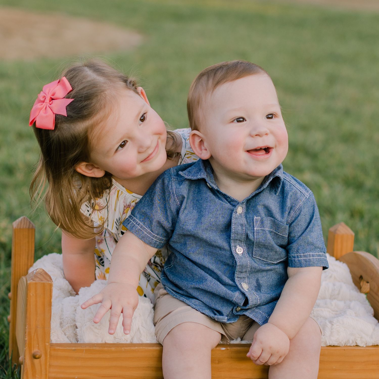 adorable cute brother and sister toddler pose on a doll bed outside