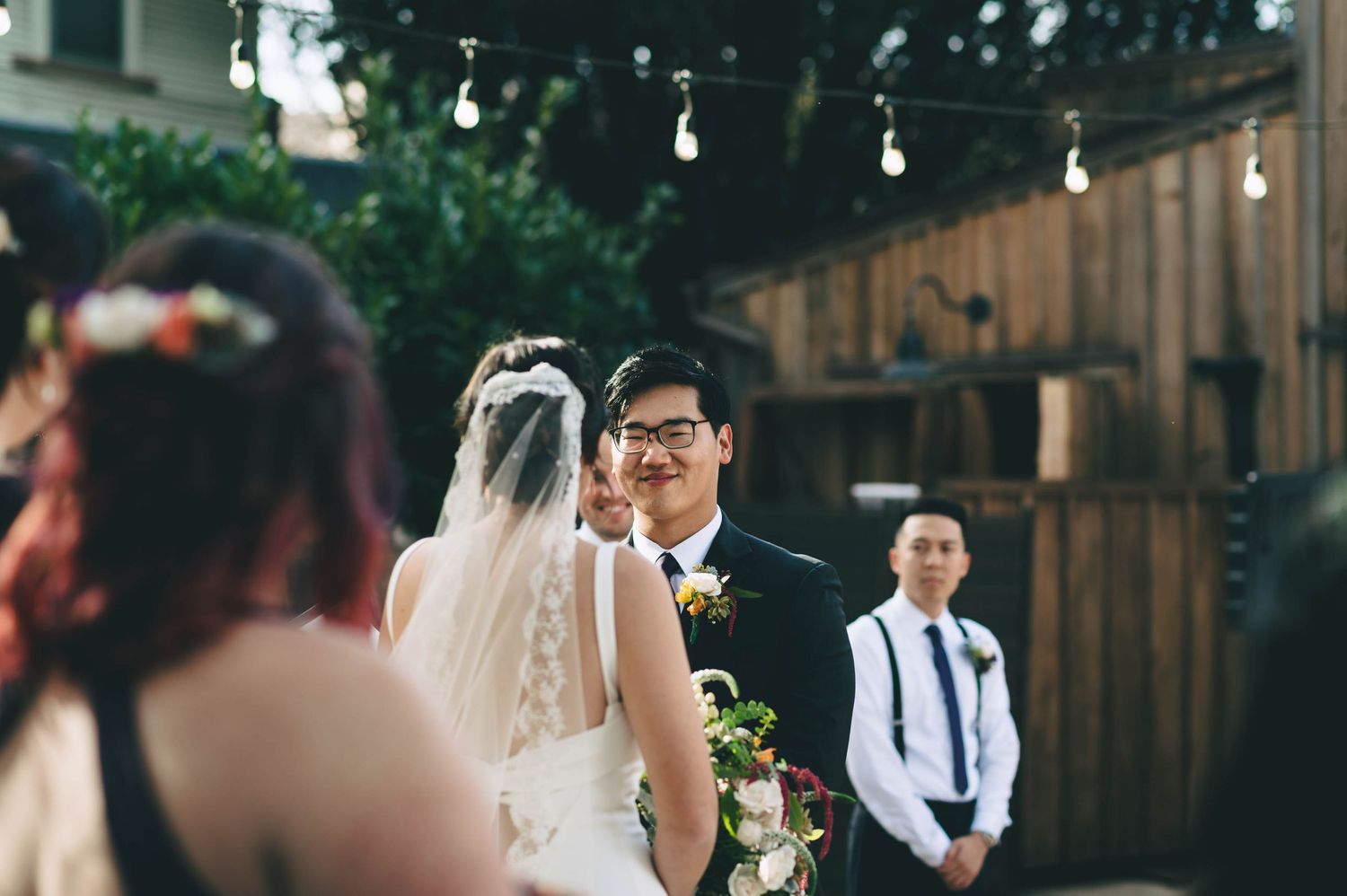 groom smiling at his bride during the ceremony.