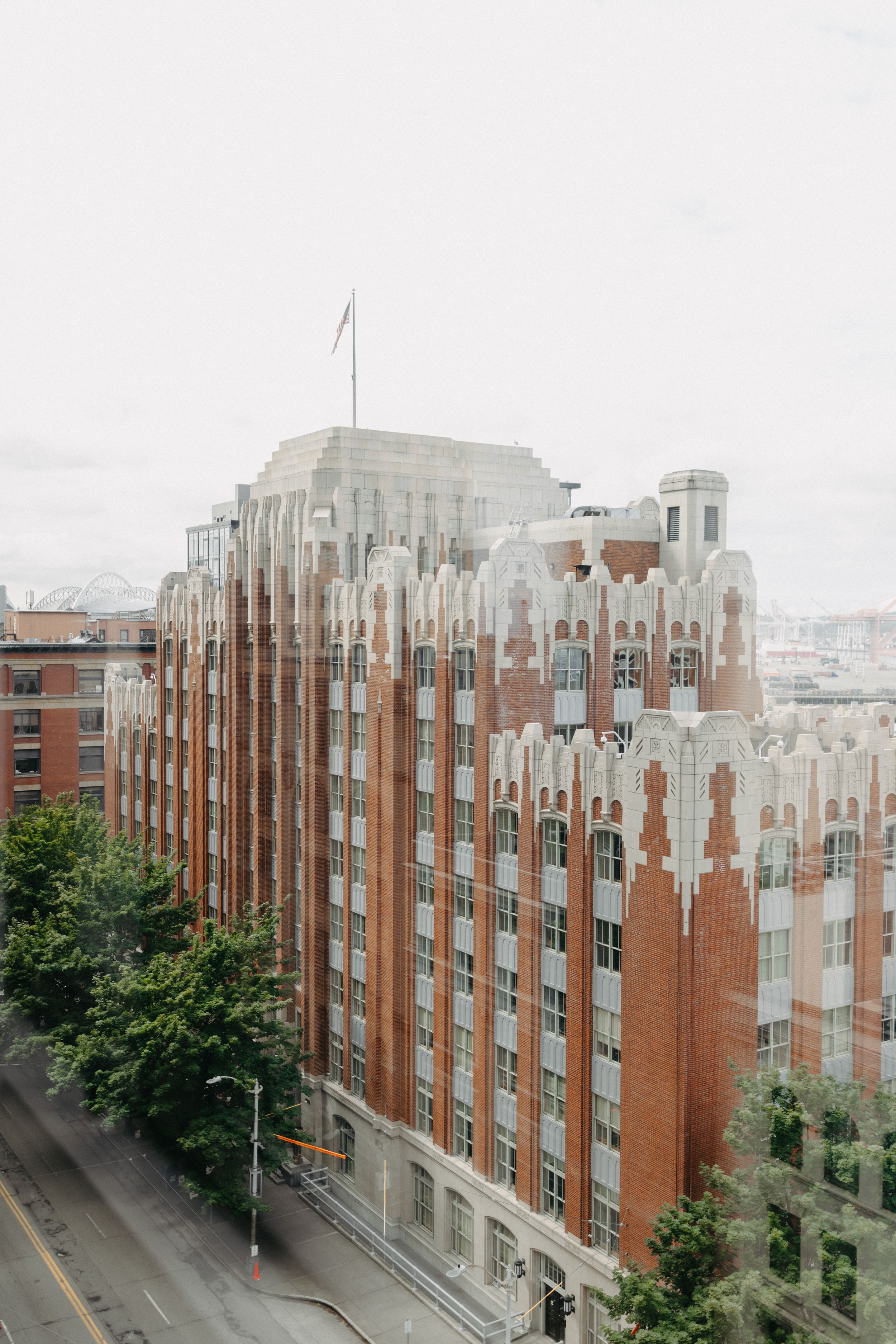 Historic Art Deco brick apartment building with ornate white architectural details against an overcast sky.