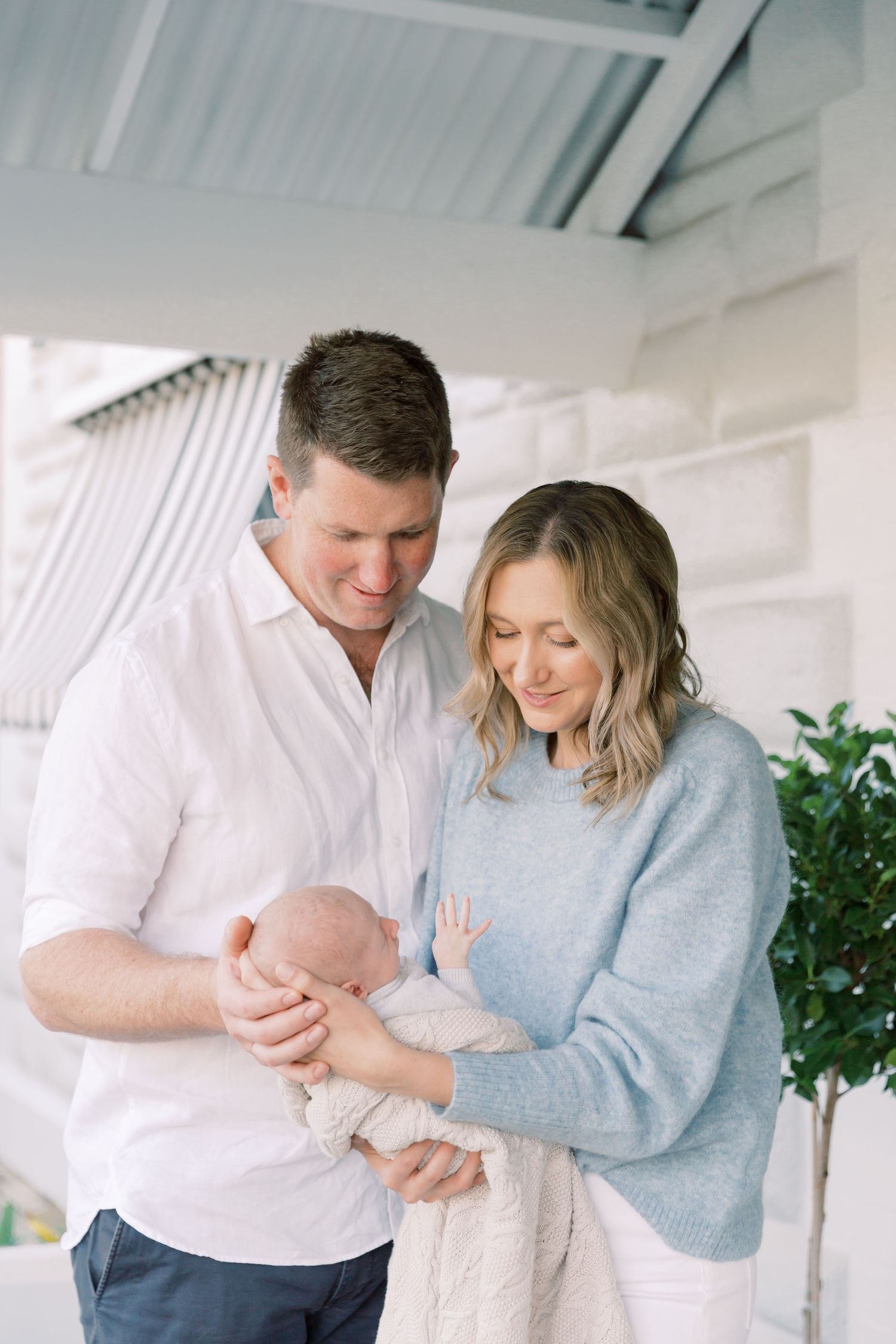 A family holding their newborn during an at home photography session.