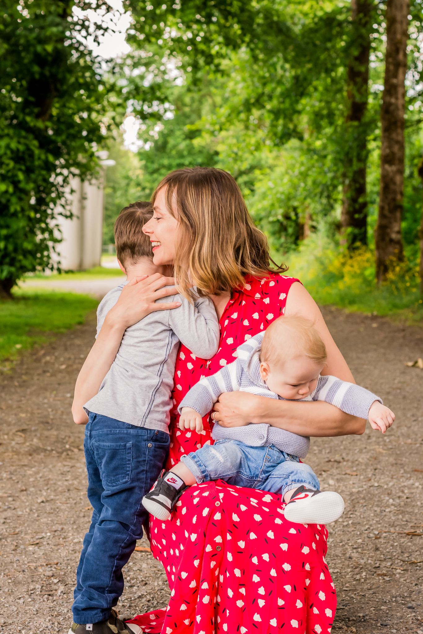 Mom and children hugging, family photo session, trees and path, summer photos