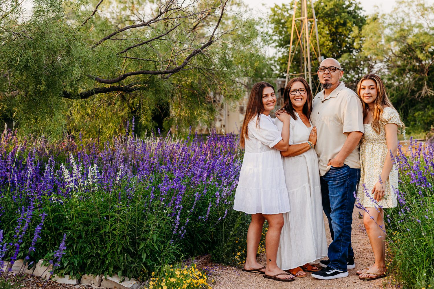 Family portrait outdoors with purple lupine flowers blooming in the background.