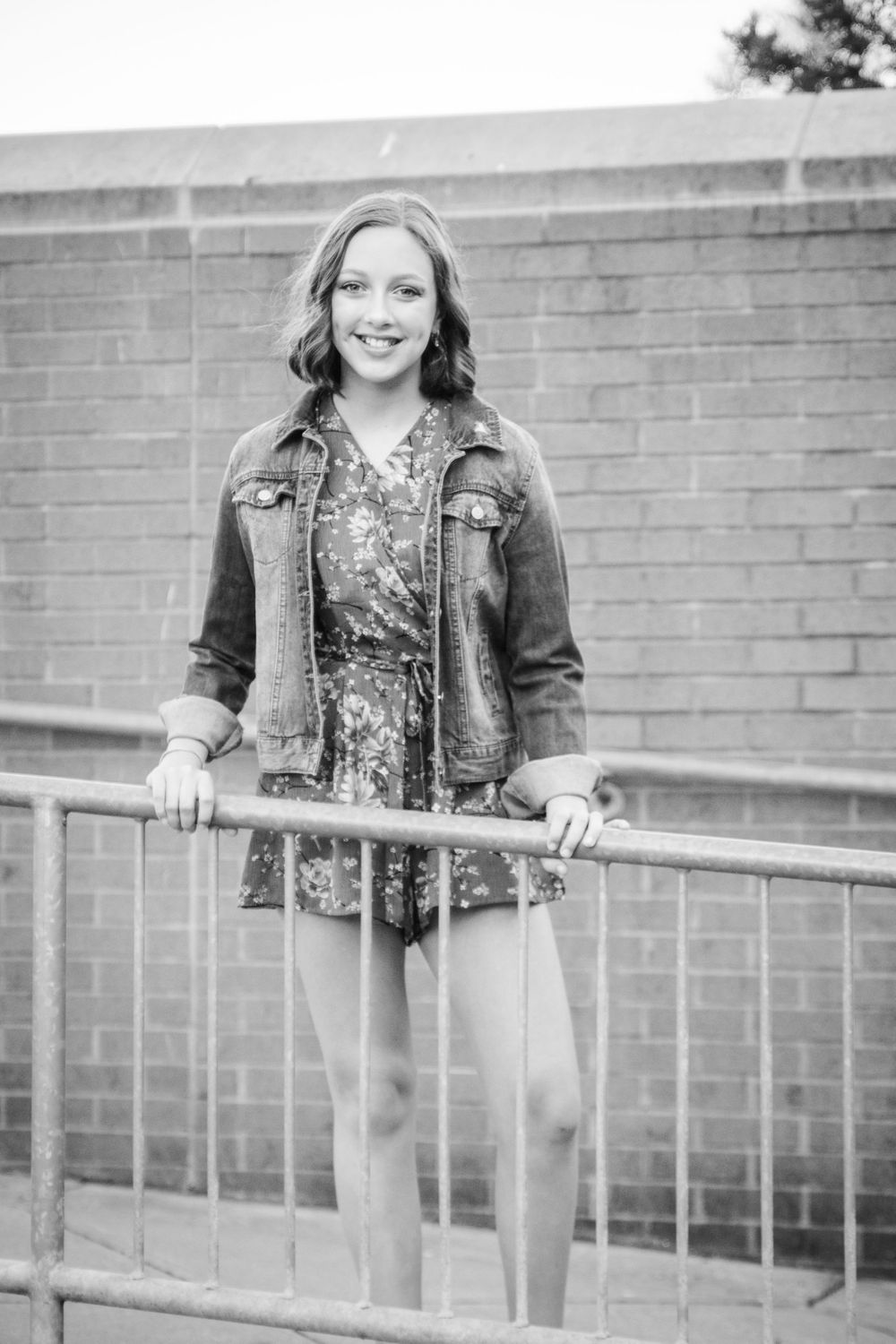 girl standing by railing jean jacket