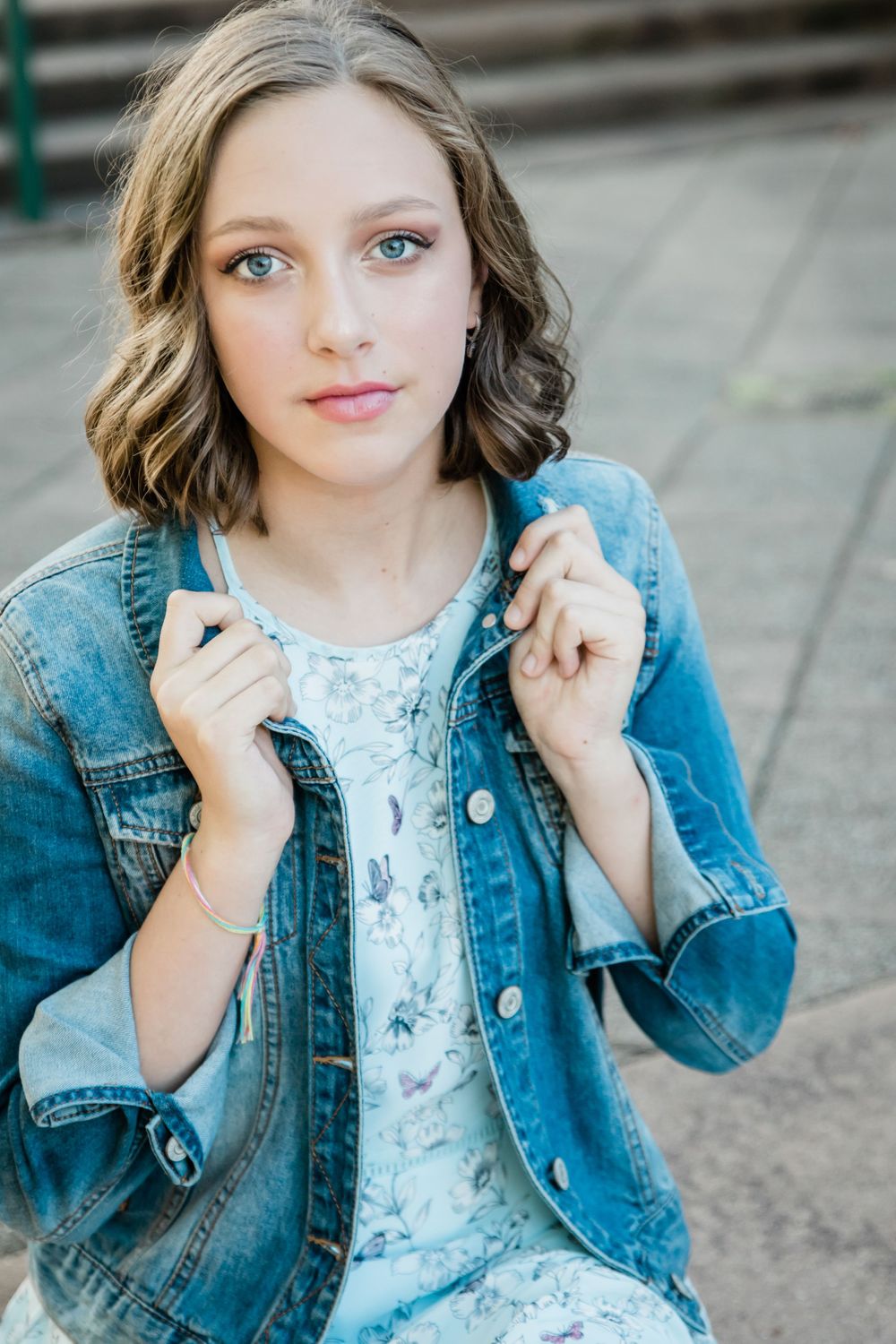 girl with beautiful blue eyes holding collar of jean jacket