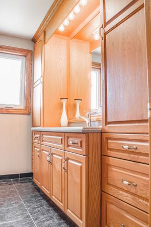 Custom built-in wooden cabinets with modern hardware in a bright room.