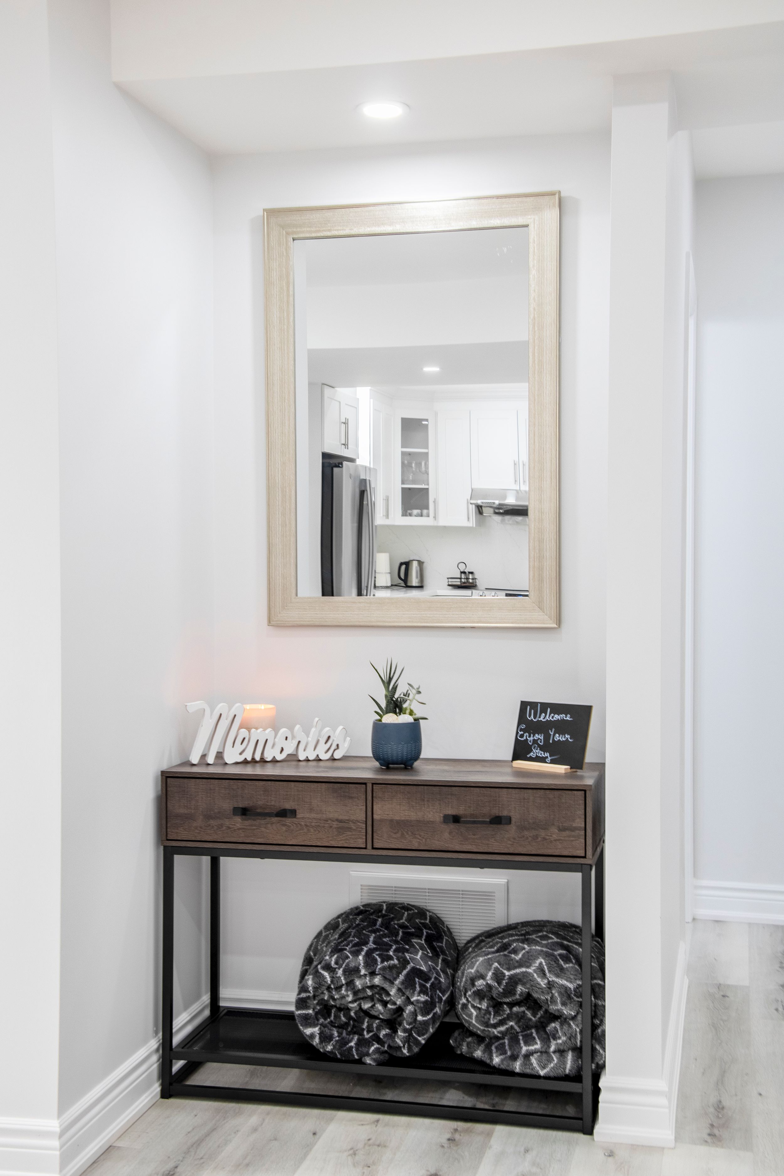 Modern entryway with industrial console table, mirror and welcome sign decor.