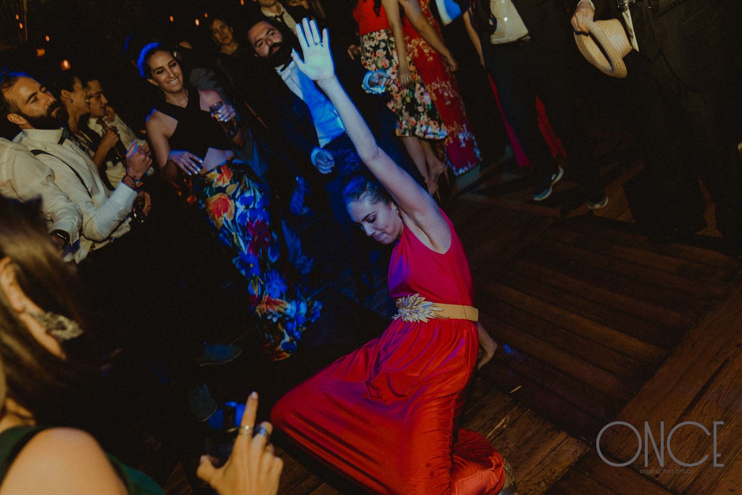 Dancers enjoying a lively celebration under dramatic blue and red lighting.