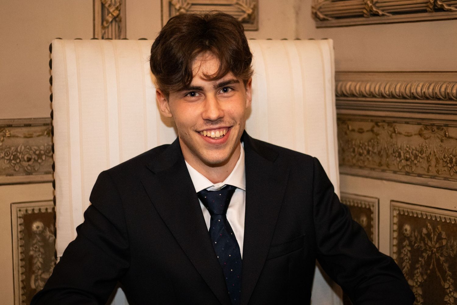 Elegant formal portraits in an ornate room with decorative moldings and classic architectural details.