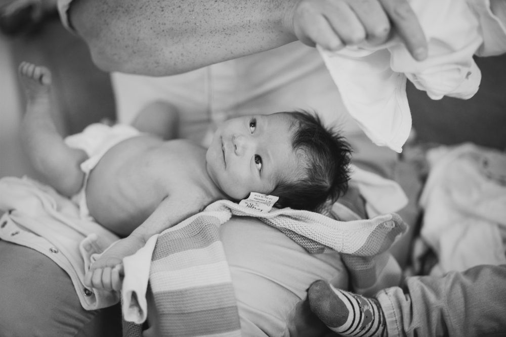 Newborn baby getting dressed for a photoshoot