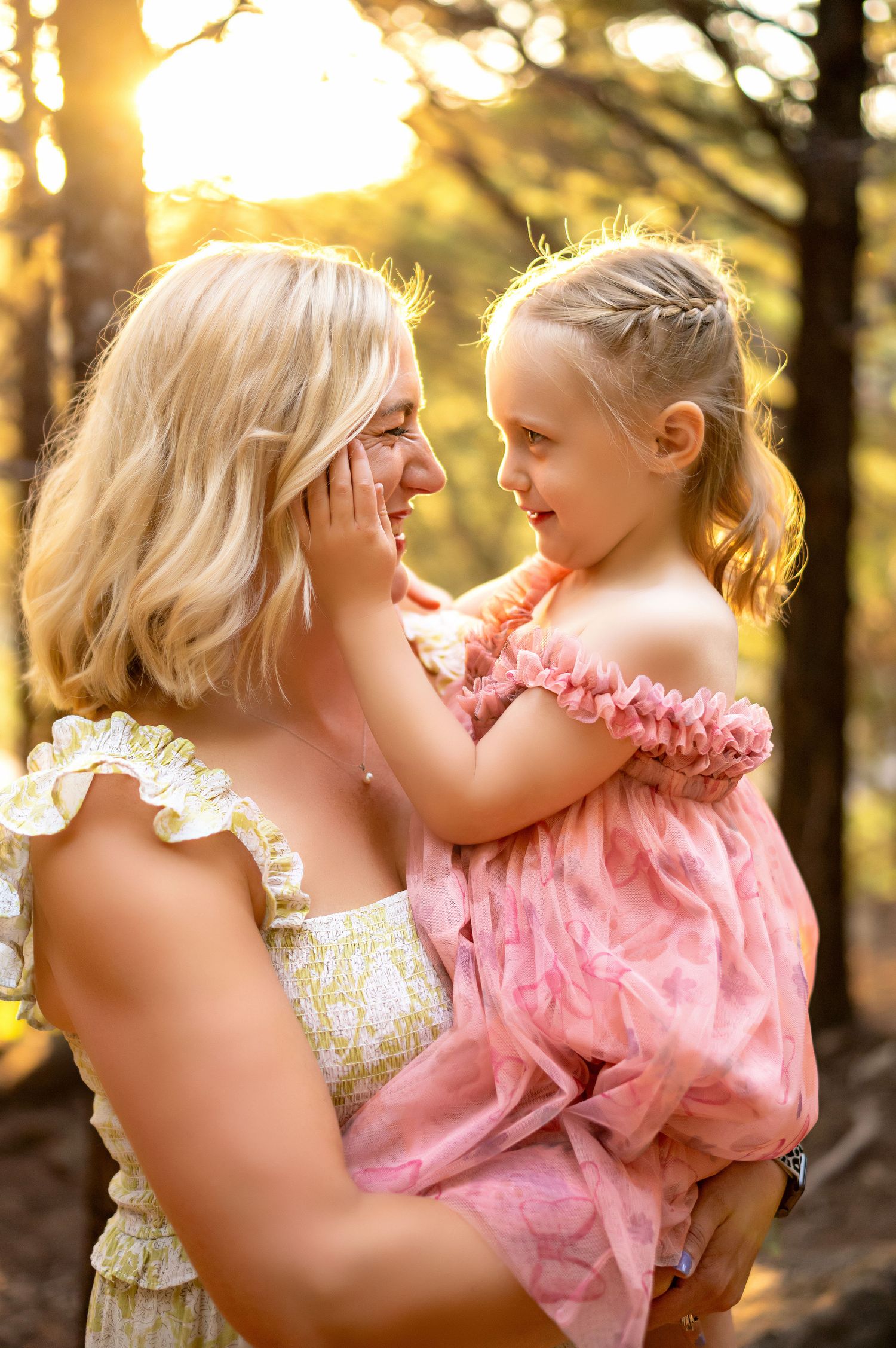 A heartwarming moment between parent and child captured in golden sunlight through trees.