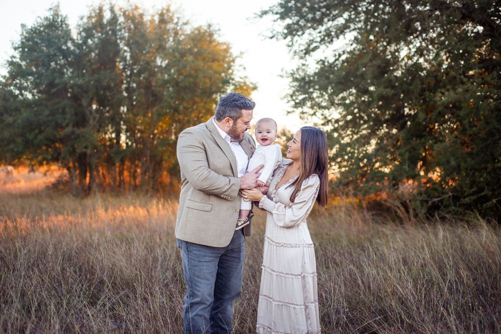 Family sharing tender moment in golden autumn field.