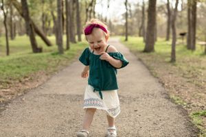 Running baby girl on park path