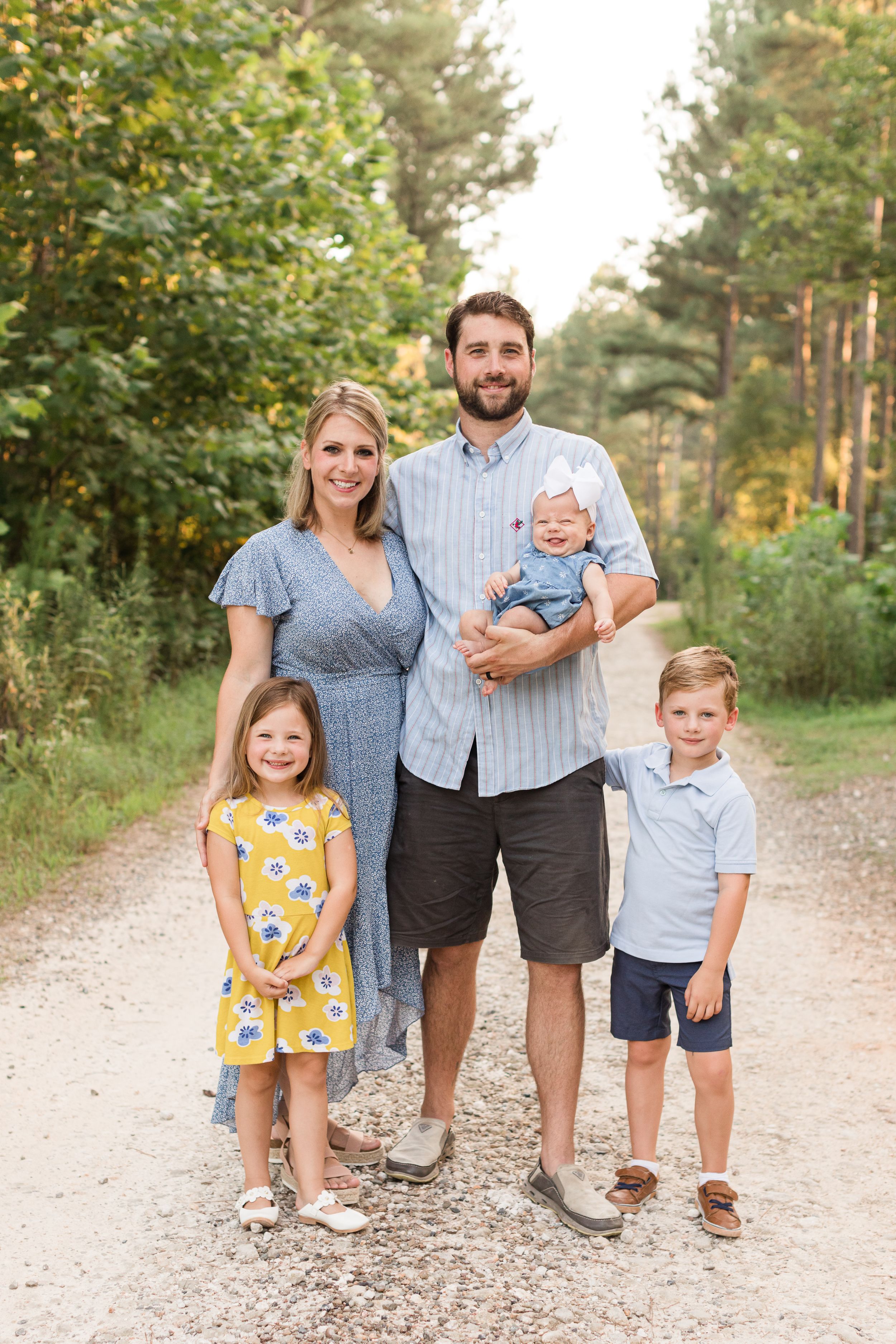 Joyful family photo of five in wooded park