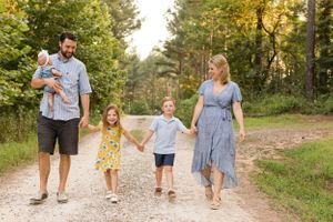 Happy family of 5 walking and laughing holding hands
