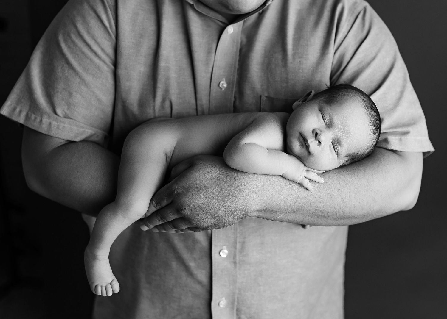 Moreno Valley newborn photographer, baby boy in dads arms in black and white